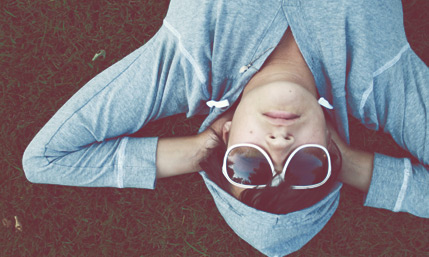 Boy laying down in grassy outdoors